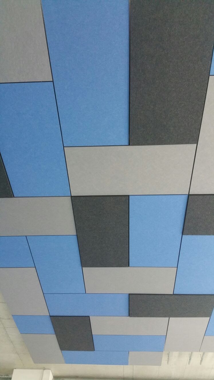 Designdecke aus blauen und grauen Akustikelementen